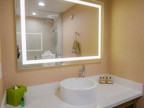 a bathroom with a sink and a large mirror at Wyndham Anaheim in Anaheim