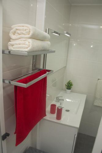 a bathroom with a sink and a red towel at Amoreira House in Calheta