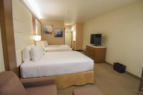a hotel room with two beds and a television at Wyndham Anaheim in Anaheim