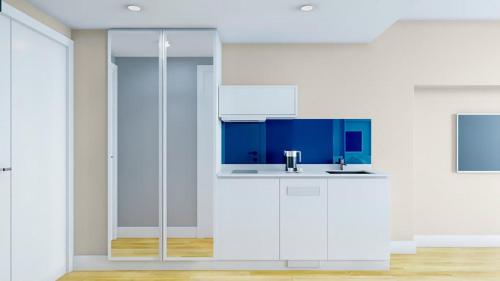 a white kitchen with a sink and blue cabinets at Orbi City Relax in Batumi