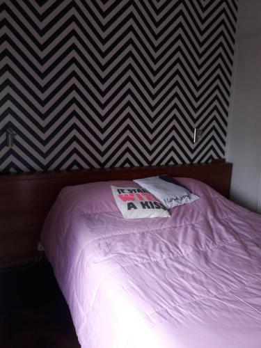 a bed with a purple comforter in a bedroom at Aurora familiar in Montevideo