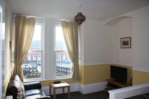 a living room with a couch and a large window at No3 By The Sea Apartment in Whitby