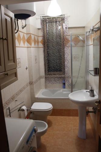 uma casa de banho com um WC, um lavatório e um chuveiro em condottieri al pigneto em Roma