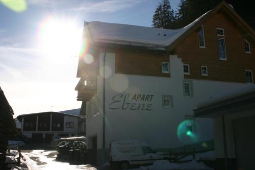 a building with the sun shining on the side of it at Apart Ebene in Ischgl