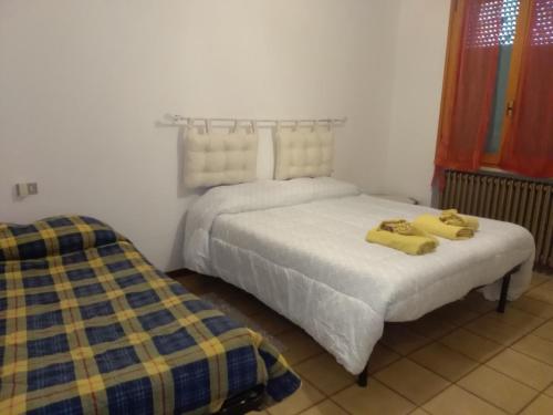 a bedroom with two beds with yellow towels on them at Maria in Rimini