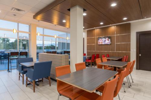 a dining room with tables and chairs and a tv at Holiday Inn Express & Suites - San Marcos South by IHG in San Marcos