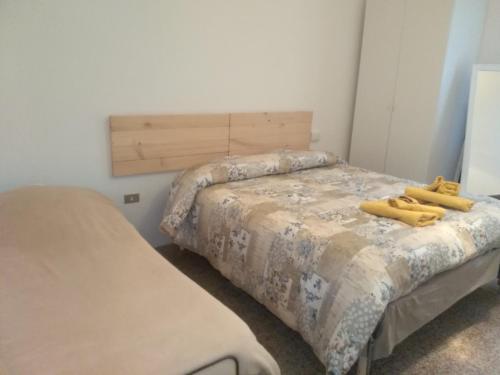 two beds in a room with two yellow beds at Maria in Rimini