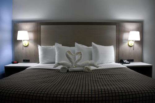 Una cama con un corazón hecho de toallas. en Destin Inn & Suites, en Destin