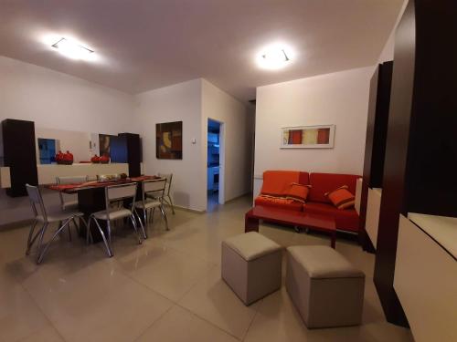 a living room with a red couch and a table at Torre Myng in Villa Carlos Paz