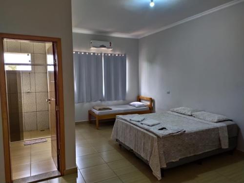 a bedroom with a bed and a walk in shower at Flex Hotel in Três Lagoas