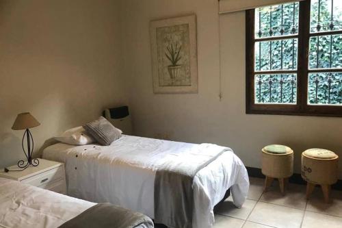 1 dormitorio con 2 camas y ventana en Casa en Chacras Mendoza , Casa LOLA en Luján de Cuyo