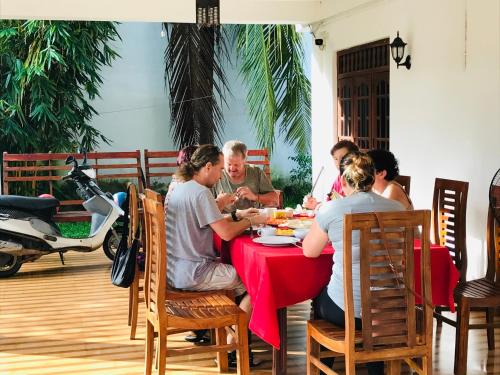 Un grupo de personas sentadas en una mesa comiendo comida en Freedom Lodge Yala, en Tissamaharama