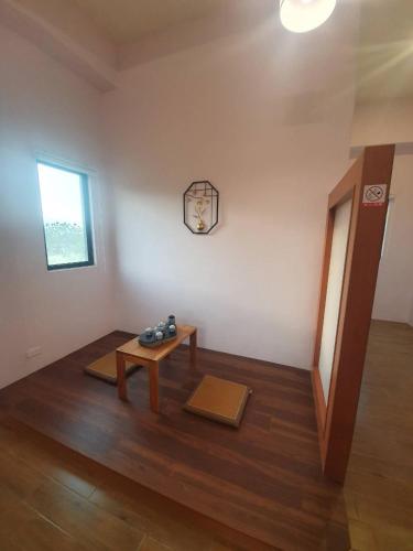 a living room with a table and a window at Clare Holiday B&B in Checheng