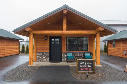 a large wooden cabin with a sign in front of it at Woodland Inns in Forks
