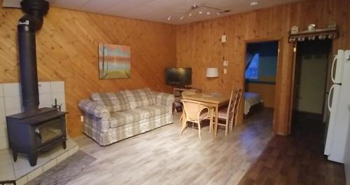 a living room with a couch a table and a stove at Oasis du grand fond Inc in La Malbaie