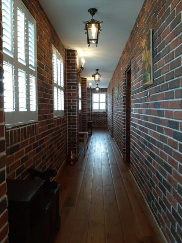 an empty hallway with a brick wall and windows at 墾丁勿忘我城堡莊園 in Hengchun