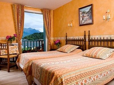 a hotel room with two beds and a window at Logis Hôtel Les Cimes in Argelès-Gazost