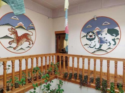 a room with three paintings on the wall with plants at Nirvana Lodge in Paro