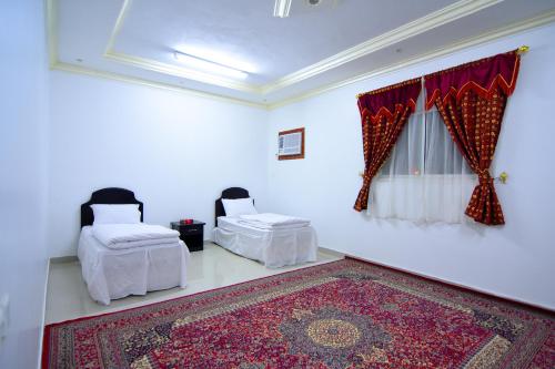 un soggiorno con 2 letti e un tappeto di Al Eairy Apartments - Al Riyad 4 a Riyad