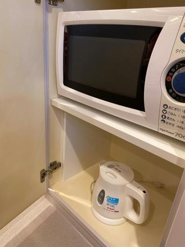a microwave oven sitting on top of a shelf at Hotel Regent (Adult Only) in Nagoya