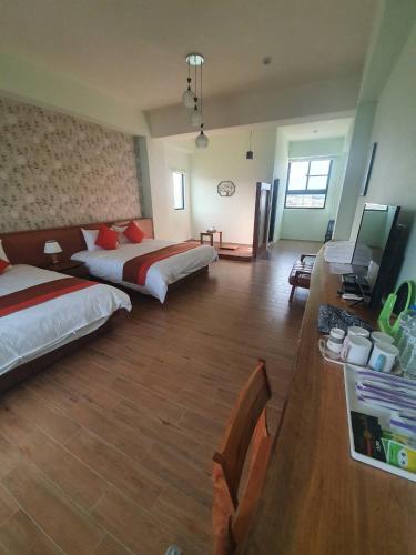 a hotel room with two beds and a desk at Clare Holiday B&B in Checheng