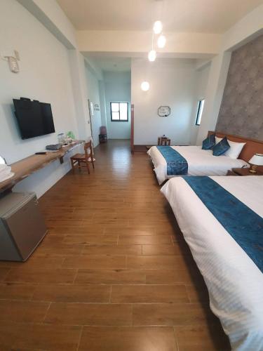 a hotel room with two beds and a flat screen tv at Clare Holiday B&B in Checheng
