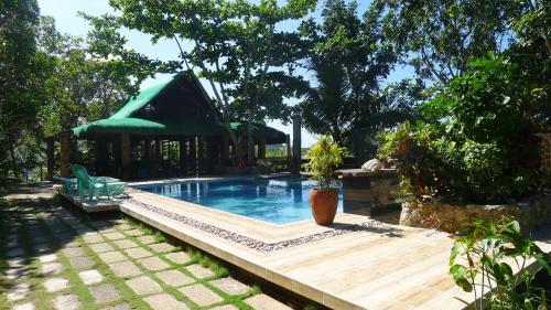 
a patio area with a pool table and chairs at La Estancia Busuanga in Busuanga
