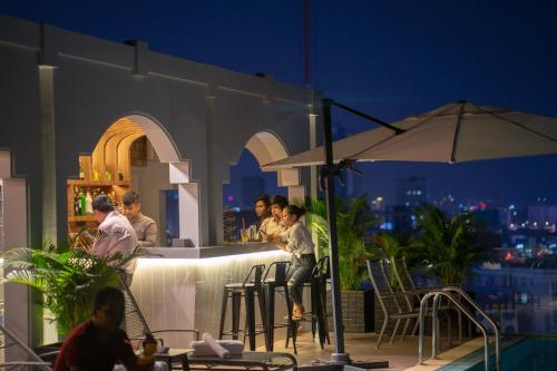 a group of people sitting at a bar on a rooftop at TK VIEW HOTEL & APARTMENT in Phnom Penh