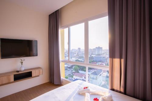 a hotel room with a bed and a large window at TK VIEW HOTEL & APARTMENT in Phnom Penh