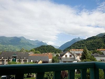 a balcony with a view of a town and mountains at Logis Hôtel Les Cimes in Argelès-Gazost