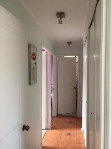 pasillo con puerta blanca y suelo de baldosa en Solvallerios Apartments, en Viña del Mar