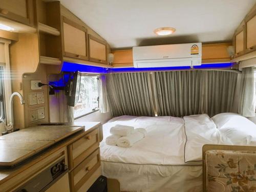 a small bedroom with a bed in a rv at Nice Nite Campervans in Phra Nakhon Si Ayutthaya