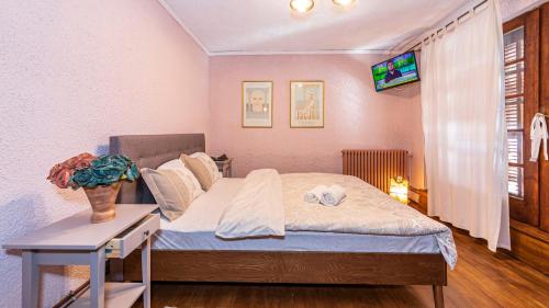 a bedroom with a bed with a table and a television at Toscana Villa in Snagov