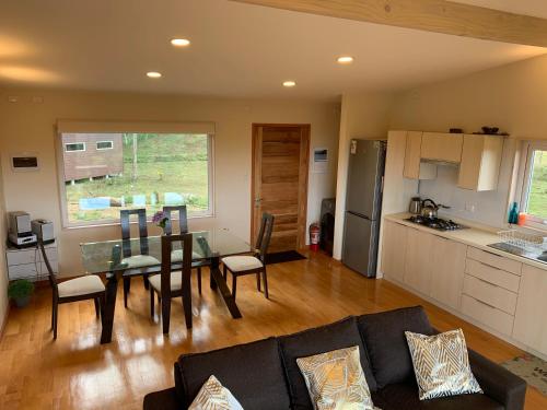 a living room with a couch and a table and a kitchen at Casa Exclusiva en Puerto Octay - Espectacular Vista in Puerto Octay