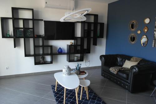 a living room with a black couch and a table at Aparthotel Palace in Praia