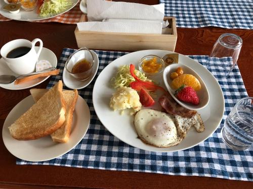 a plate of breakfast food with eggs toast and fruit at Support Inn Minami-Chita Annex Hamachaya in Minamichita