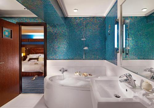 un bagno con vasca e lavandino e una camera da letto di Crowne Plaza Athens City Centre, an IHG Hotel ad Atene