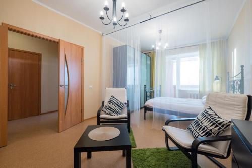 a living room with a couch and a bed at OK! Розы Люксембург in Tomsk