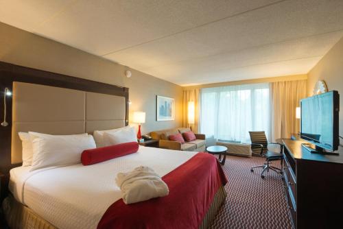 a hotel room with a bed and a television at Crowne Plaza Boston - Woburn by IHG in Woburn