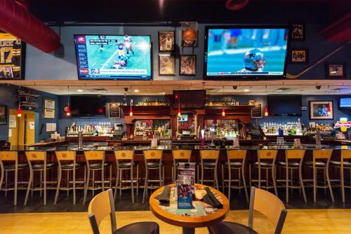 a bar with chairs and televisions on the wall at Crowne Plaza Boston - Woburn by IHG in Woburn