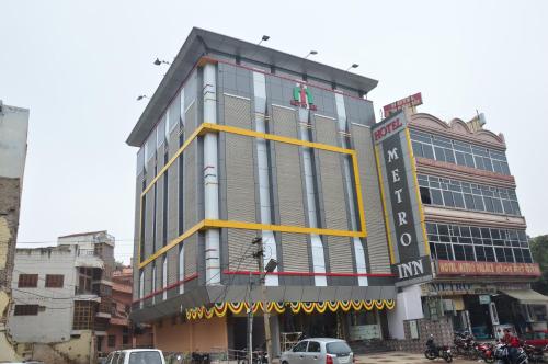 a building on a city street with cars in front of it at Hotel Metro Inn in Ajmer