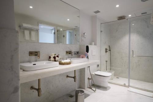 a bathroom with two sinks and a shower and a toilet at Brij Nest, Jaipur - An All Suite Boutique Hotel in Jaipur