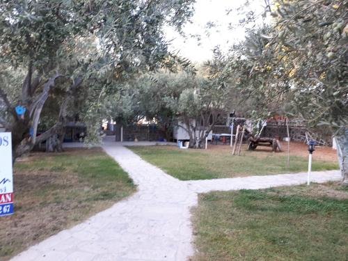 a path in a park with trees and a fire hydrant at BERGOS LİMAN in Çanakkale