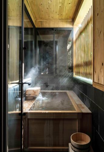 a kitchen with a tub with smoke coming out of it at Shiro Nozawa in Nozawa Onsen
