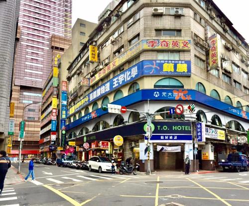 a busy city street with a traffic light and buildings at T.O. Hotel - Taipei station in Taipei