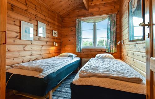 a bedroom with two beds in a log cabin at Beautiful Home In Ringkbing With 3 Bedrooms, Sauna And Wifi in Klegod