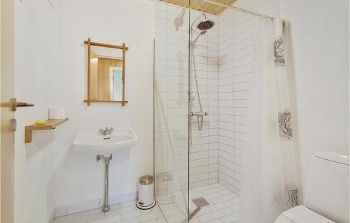 a white bathroom with a shower and a sink at Four-Bedroom Holiday Home In Tranekar in Tranekær