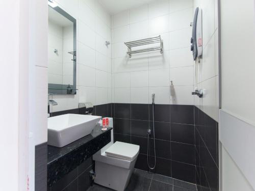 a bathroom with a sink and a toilet and a mirror at Top Garden Hotel in Hutan Melintang