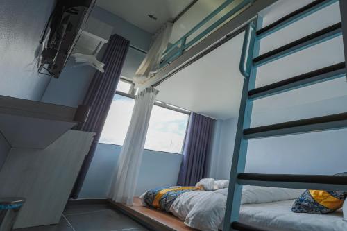 a bedroom with a bunk bed and a window at Top Garden Hotel in Hutan Melintang