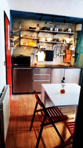 een keuken met een aanrecht, een tafel en een koelkast bij A due passi dal cielo in Passo del Tonale